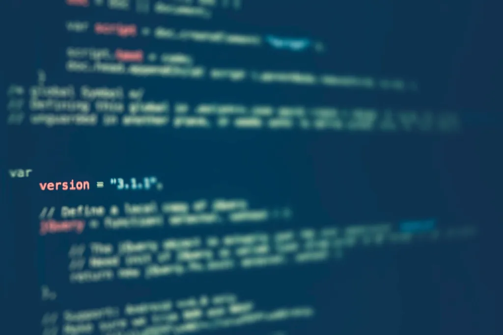 Blurred close-up of a screen showing JavaScript code on a deep blue background
