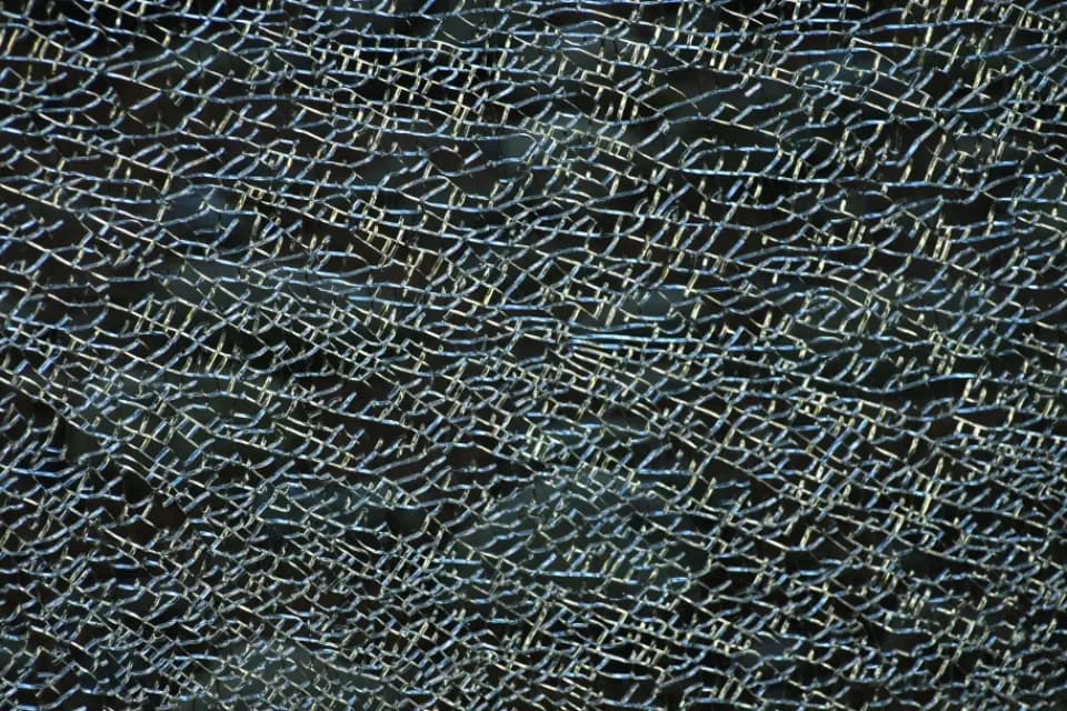 Close-up of shattered glass forming a web of cracks