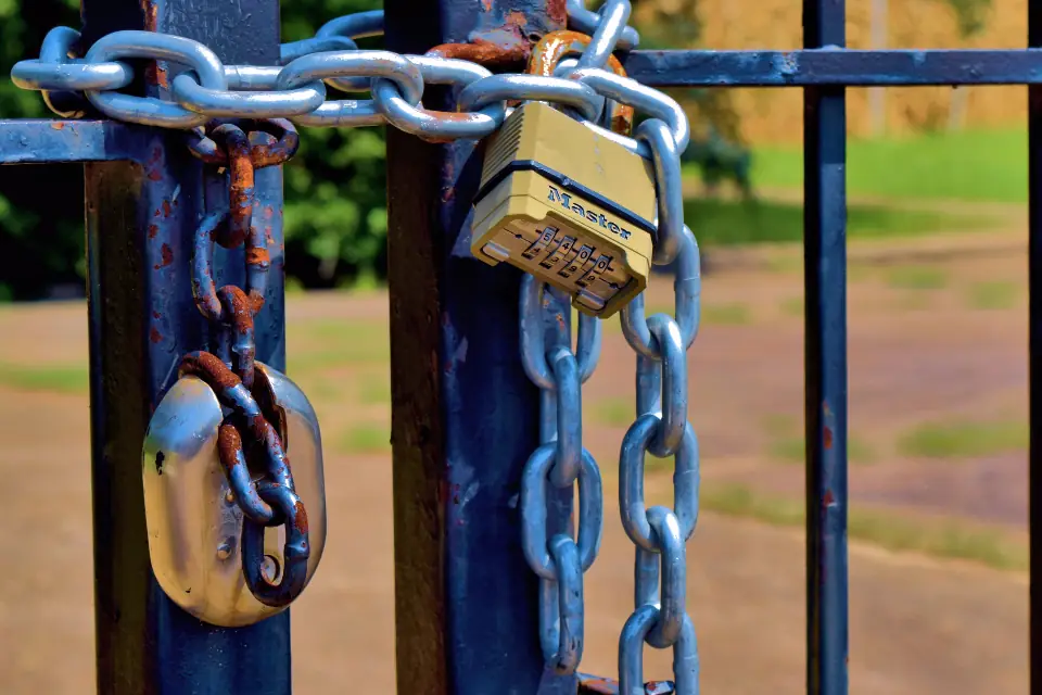 Padlocks and chains on a blue metal gate