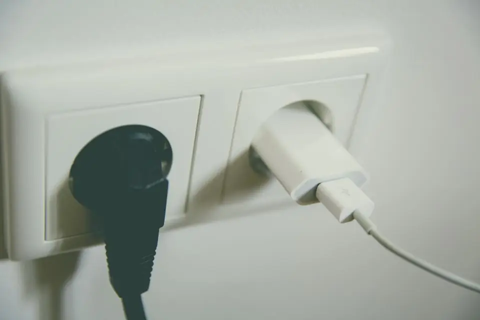 Two plugs connected to a white wall socket